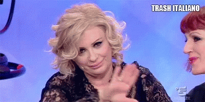 two women are sitting next to each other and one of them is wearing a black lace top .