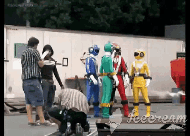 a group of power rangers are standing next to each other on the set of a movie .