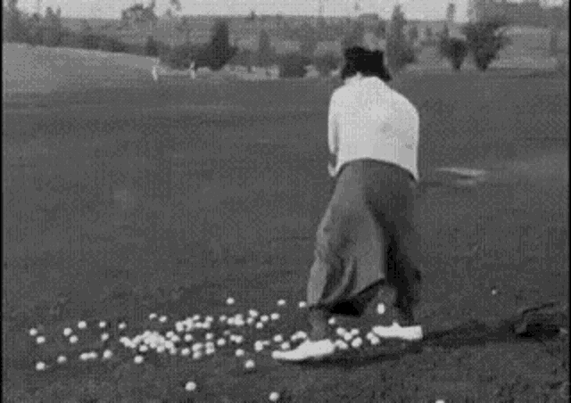 a man is hitting golf balls on a golf course .