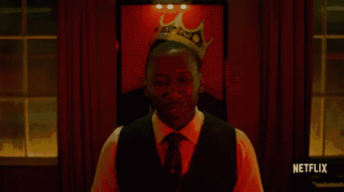 a man with a crown on his head is standing in front of a netflix sign