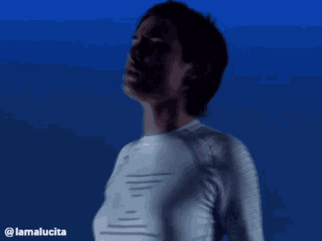 a woman in a white shirt is standing in front of a blue background with the hashtag @lamalucia