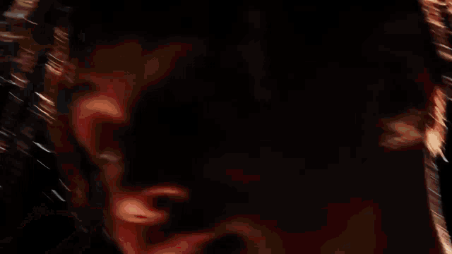 a close up of a man 's face with his hands on his face