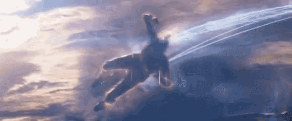 a person is flying through a cloudy sky with a blue light coming out of it