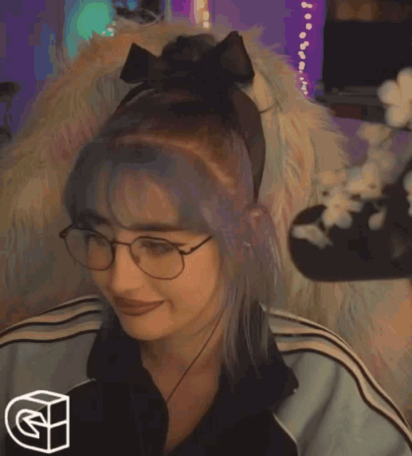 a woman wearing glasses is making a heart with her hands .