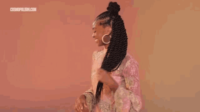 a woman in a pink dress is dancing with her hair in the wind .