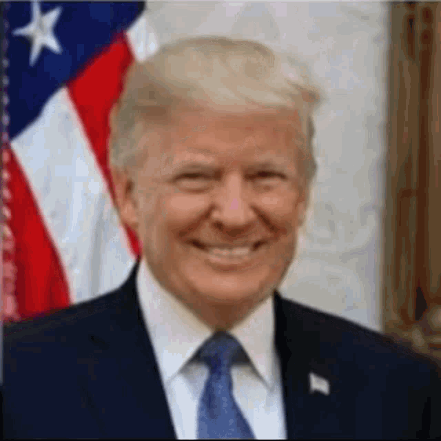 president donald trump is smiling in front of an american flag while wearing a suit and tie .