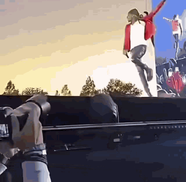 a person is taking a picture of a man in a red jacket