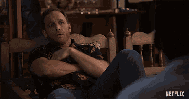a man sitting in a chair with a netflix logo on the bottom right