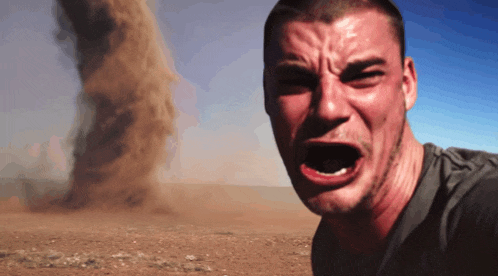 a man is crying in front of a sandstorm