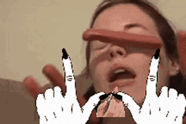 a woman is holding a sausage in her mouth and making a middle finger sign .