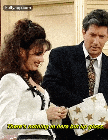 a man and a woman are standing next to each other and the woman is holding a piece of paper with stars on it .