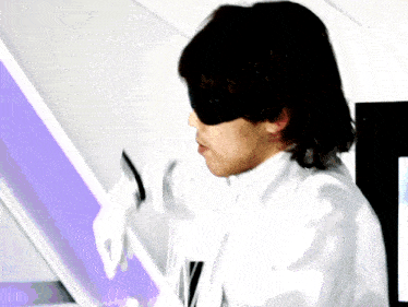 a man wearing a blindfold and white gloves is looking at a screen