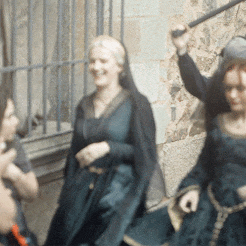 a woman in a black dress is holding a sword in her hand