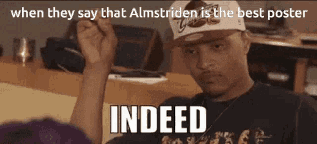 a man wearing a hat holds his fist in the air and says " indeed "
