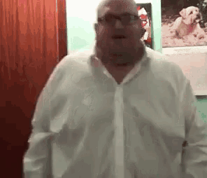 a man in a white shirt and tie is standing in a room .