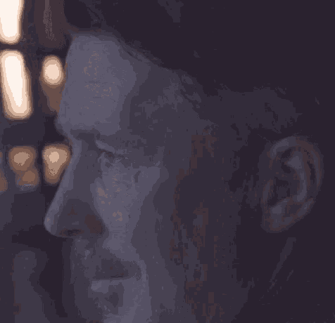 a close up of a man 's face in the dark .