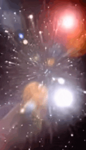 a blurred image of a fireworks display in a dark night sky