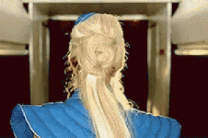 a woman with long blonde hair is wearing a blue jacket