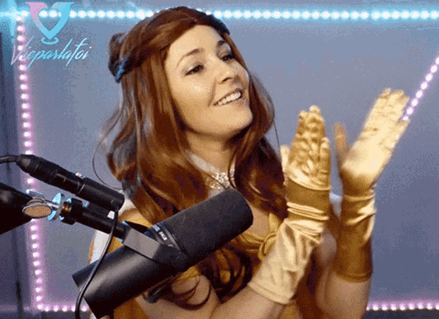 a woman in a beauty and the beast costume is standing in front of a microphone