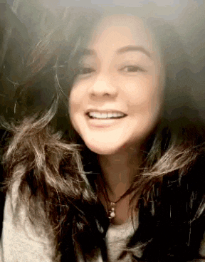 a woman with long hair is smiling for the camera .