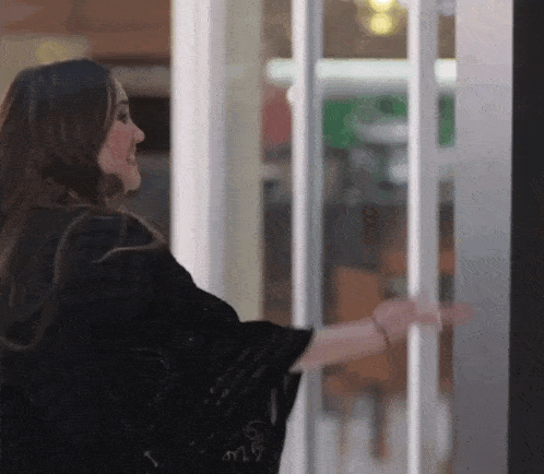 a woman is standing in front of a glass door with the letters m17 on it