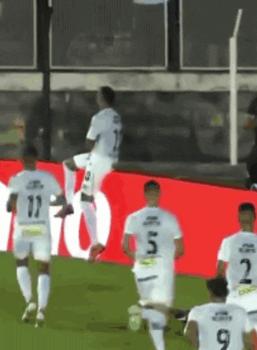 a group of soccer players are running on a field and one of them has the number 9 on their jersey