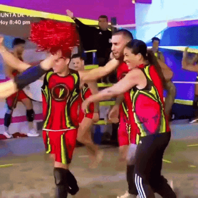 a group of people are dancing in front of a sign that says hoy 8:40 pm on it