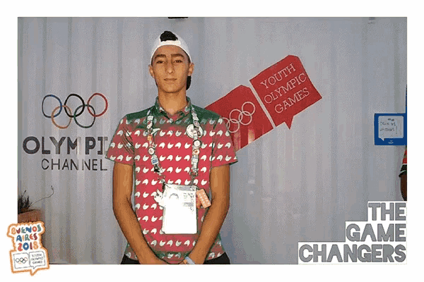 a man stands in front of an olympic channel sign