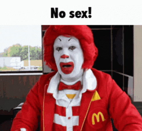 a mcdonald 's clown with a red wig and a m on his jacket