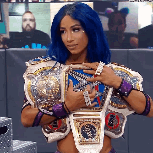 a woman with blue hair is holding a world heavyweight championship belt .