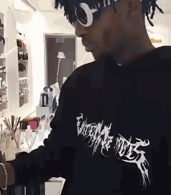 a man wearing sunglasses and a black shirt that says ' vengeance rides ' on it
