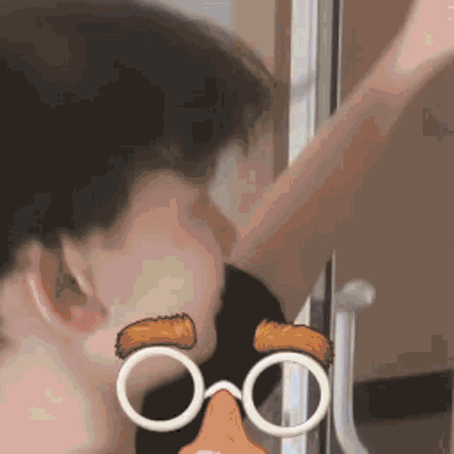a close up of a person 's face with a cartoon face and glasses .