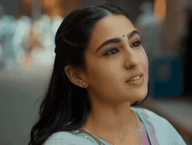 a close up of a woman 's face with a blue bindi