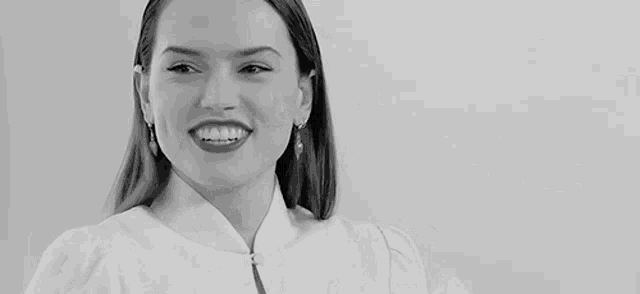 a black and white photo of a woman making a funny face and smiling .
