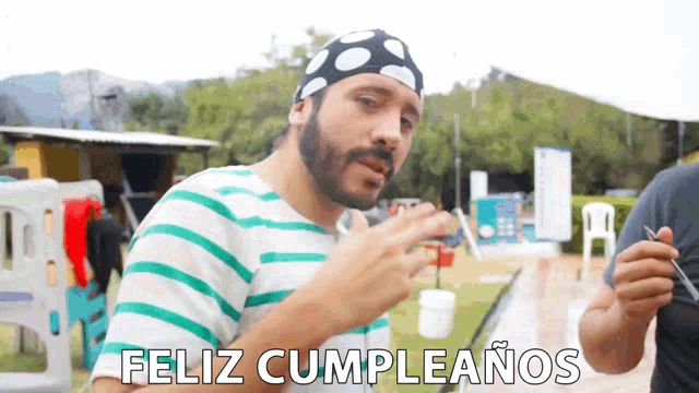 a man wearing a bandana says feliz cumpleanos in spanish