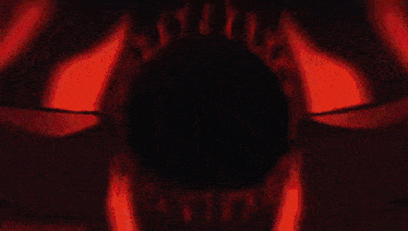a close up of a person 's hand holding a red object in a dark room .