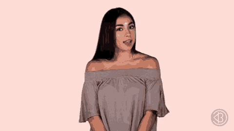 a woman in a grey off the shoulder top is winking at the camera .