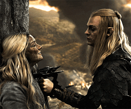 a man and a woman are standing next to each other and the man is holding a sword