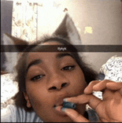 a woman is smoking a cigarette and has a snapchat sticker on her head that says i'm okay