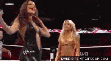 two women are standing in a wrestling ring and one of them is wearing a black dress
