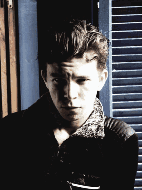 a close up of a young man 's face with a serious look on his face