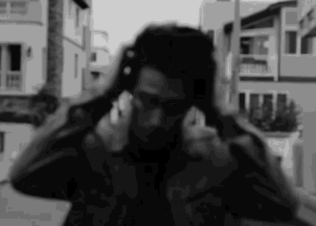 a man covering his ears with his hands in a black and white photo