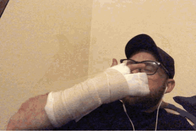 a man with a bandage on his hand and glasses