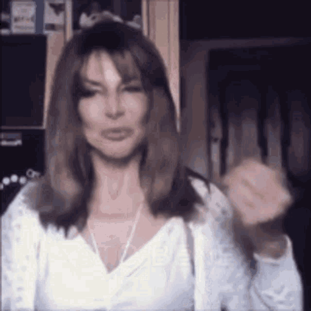 a woman in a white shirt is making a funny face