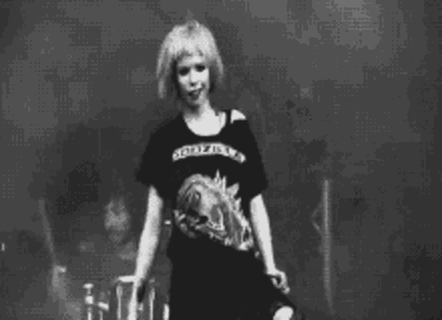 a black and white photo of a woman wearing a t-shirt that says `` godzilla '' .