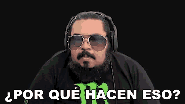 a man with a beard and sunglasses is wearing headphones and a shirt that says monster .
