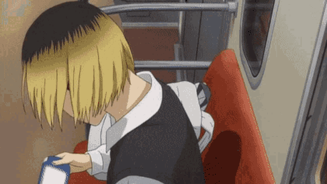 a person is sitting on a subway car holding a box of milk .