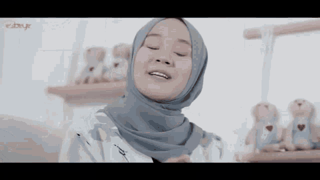 a woman wearing a hijab is smiling and looking at the camera .