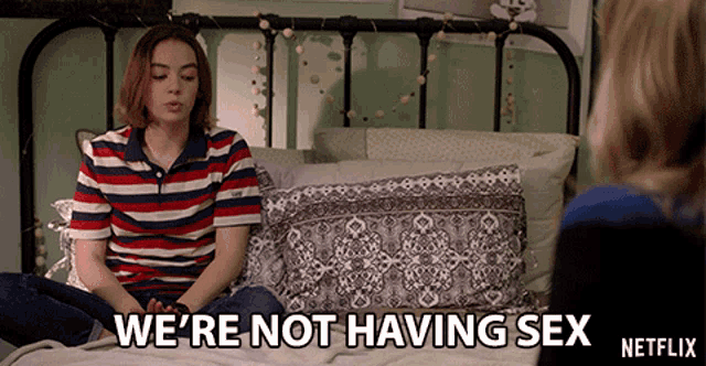 a girl is sitting on a bed with the words " we 're not having sex " on the bottom