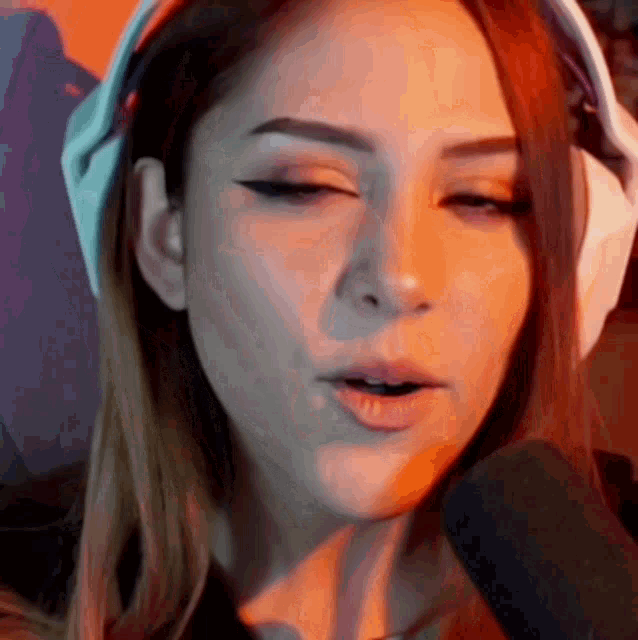 a close up of a woman wearing headphones talking into a microphone
